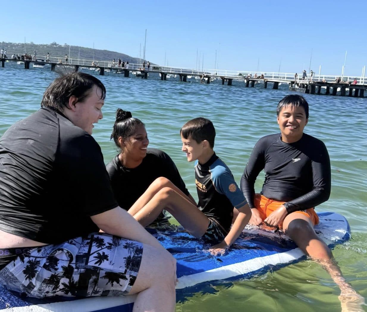 Participants and support workers out on paddleboards
